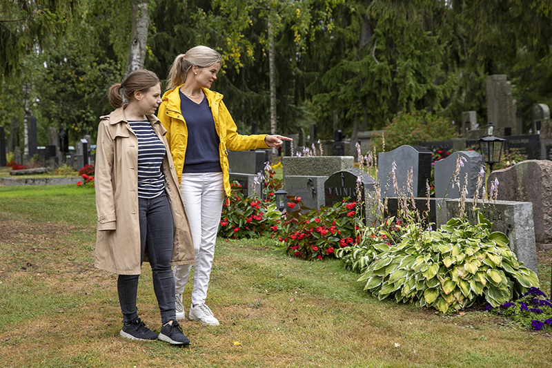 Tuottaja Anni Mylläri ja tiedottaja Eva Wäljas kävelevät Kalevankankaan hautausmaalla ja katselevat hautakiviä.