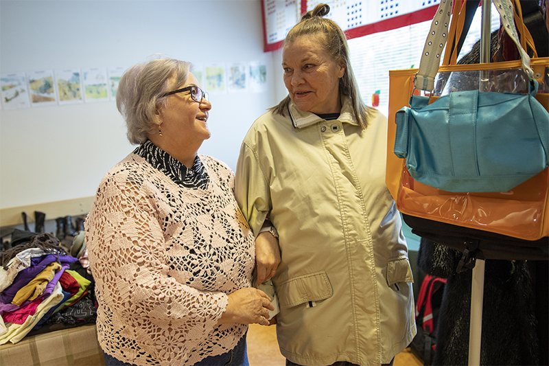 Diakoniapäivään saapunut Anneli Laine sovittelee takkia kierrätyspäällikkö Hilkka Branderin avustamana.