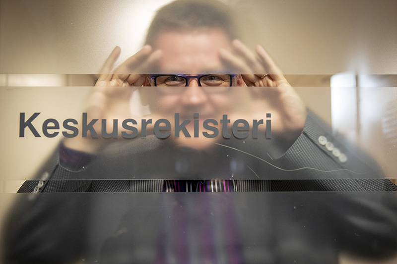 Rekisteripäällikkö Kari Salonen katsoo Keskusrekisterin oven läpi.