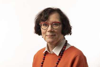 Silta-lehden vuoden 2020 kolumnistin, Marja Jylhän studiokuva. Jylhällä on yllään oranssi neule ja silmälasit, joiden sangat ovat kaksiväriset – mustat ja punaiset. Jylhä näyttää asiantuntevalta ja rennolta.
