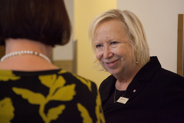 Hymyilevä Elina Karttunen juttelee kuvassa selin olevan naisen kanssa.