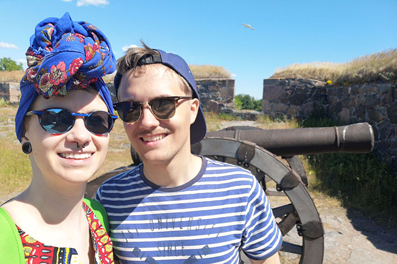 Kihlatut hymyilevät turistikohteessa, tausta vanha tykki.