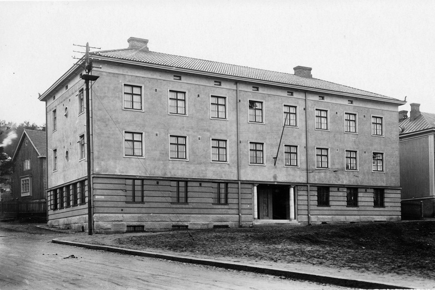 Mustavalkoinen kuva vanhasta kivitalosta.