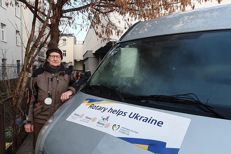 Pipopäinen mies seisoo pakettiauton keulan takana. Keulassa lukee teksti Rotary helps Ukraine.