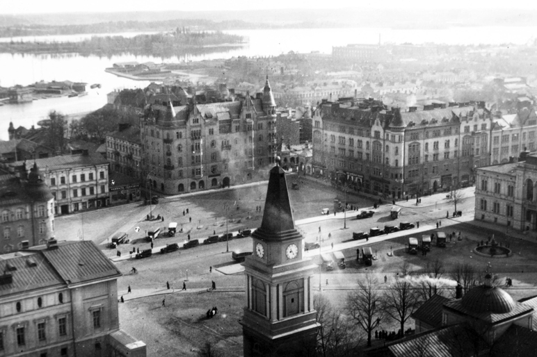 Mustavalkoinen ilmasta otettu kuva vuoden 1933 Tampereen keskustasta. Keskellä kirkon torni ja ympärillä kivitaloja.