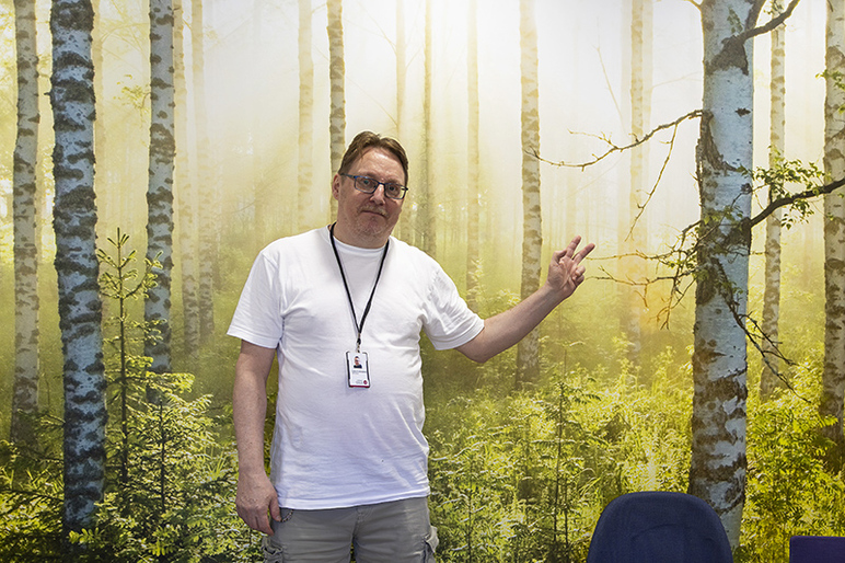 Mies seisoo metsämaiseman edessä.