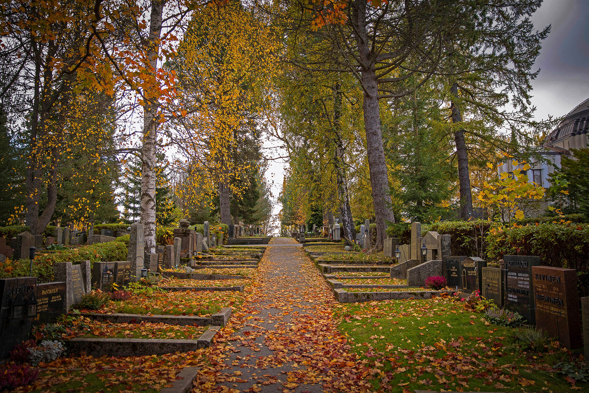 Syksyisen hautausmaan hiekkatie hautapaikkojen välissä.