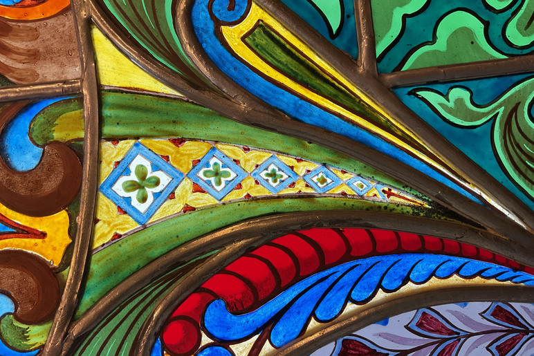 Värikkäitä kaarevia kuvioita muodoissa, joita kehystävät metalliset reunat.