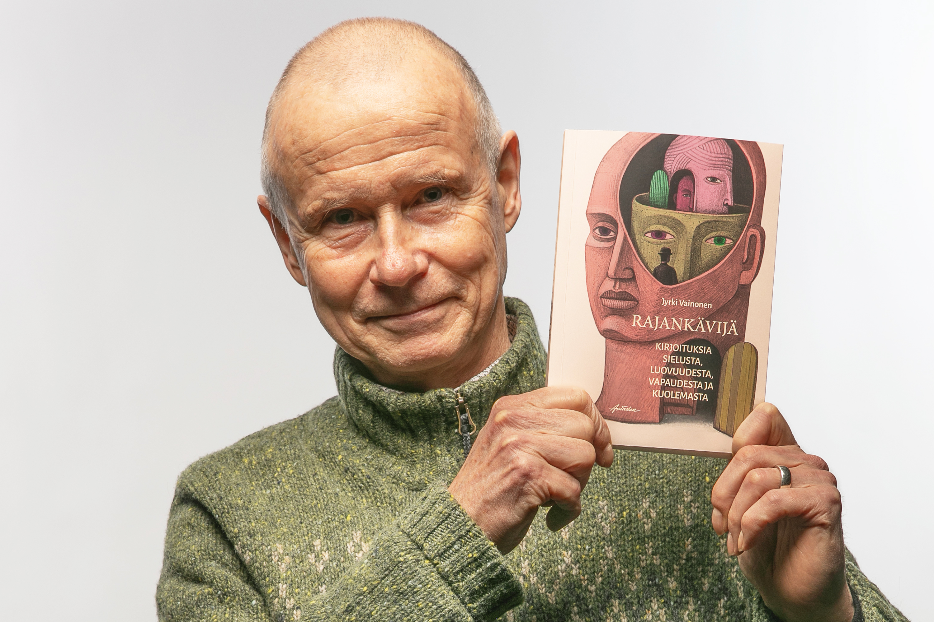 Henkilö nostaa esiin kiinni olevaa kirjaa.