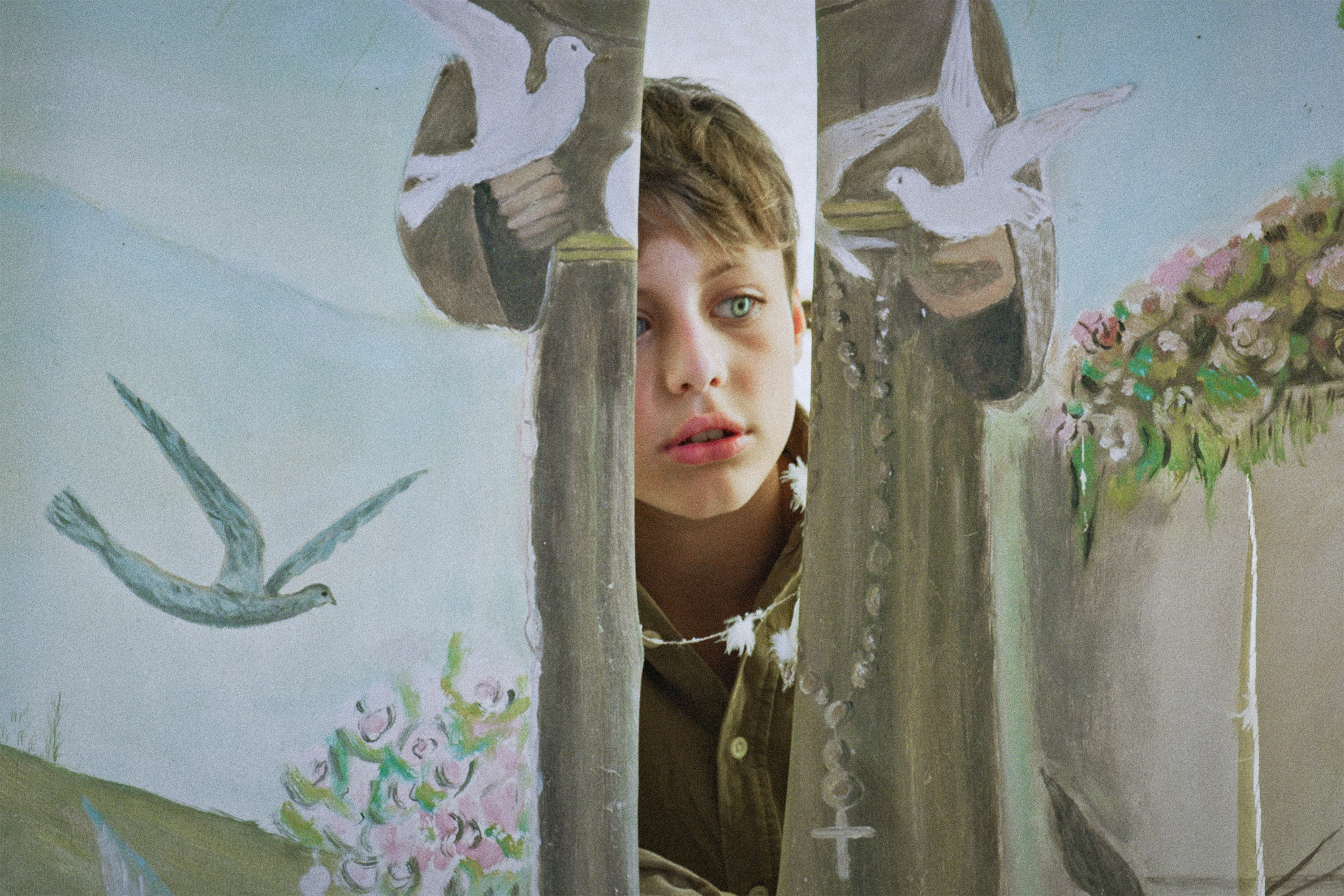 Lapsi kurkistaa verhojen raosta.