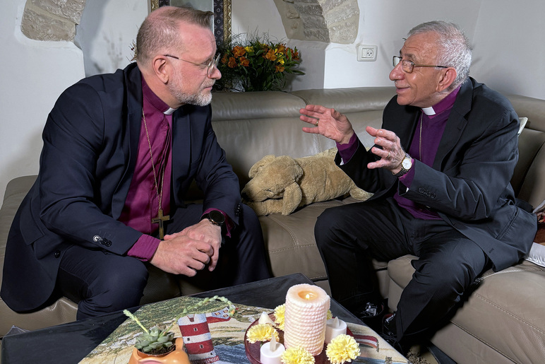 Kaksi henkilöä keskustelee pöydän ääressä.